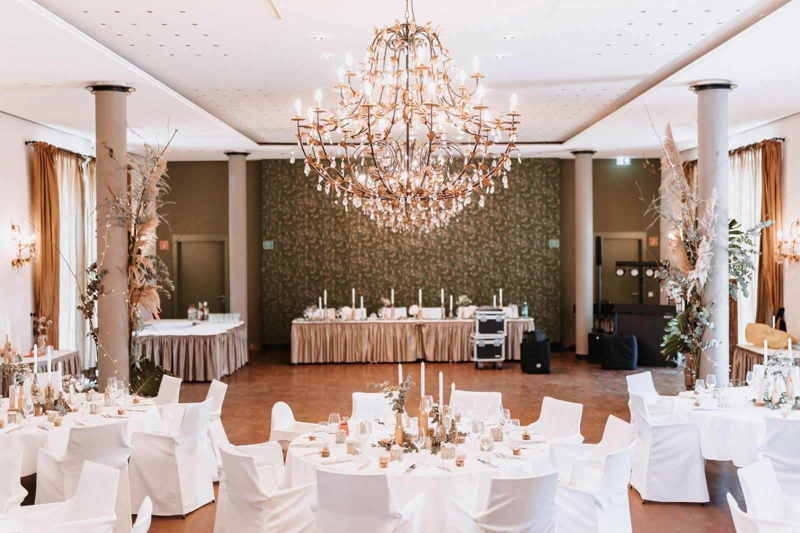 Svečana sala sa lusterom i okruglim stolovima za svadbu